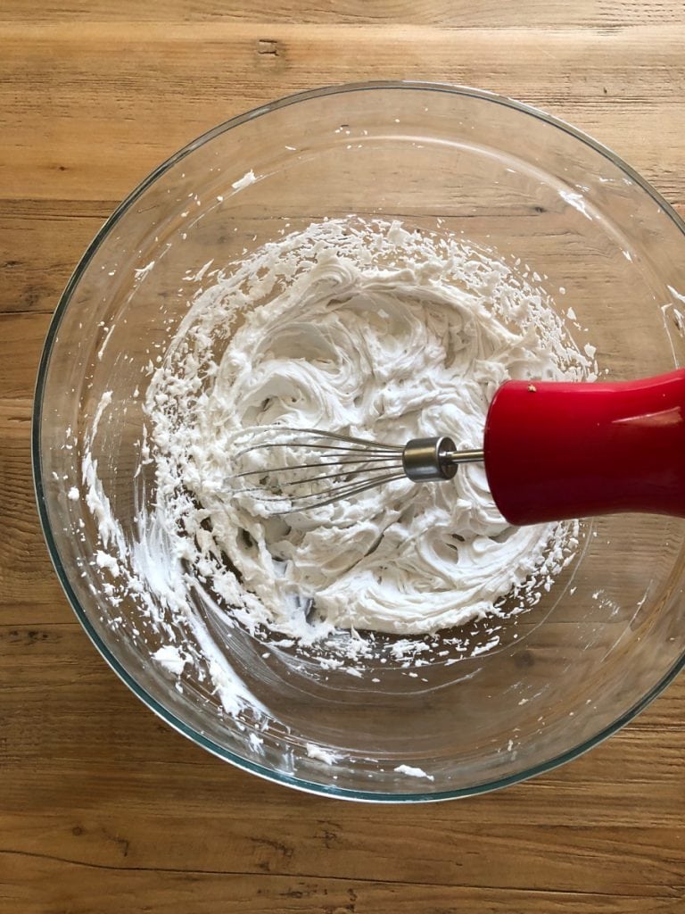 Whipped coconut cream in a glass bowl on a wooden table