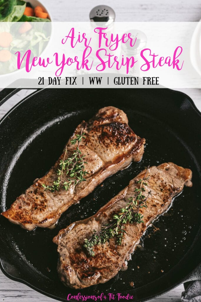 Overhead photo of Two New York Strip Steaks grilled in a Cast Iron Skillet with salt and pepper shakers and a salad in the background. With the text overlay- Air Fryer New York Strip Steak | 21 Day Fix | WW | Gluten Free | Confessions of a Fit Foodie