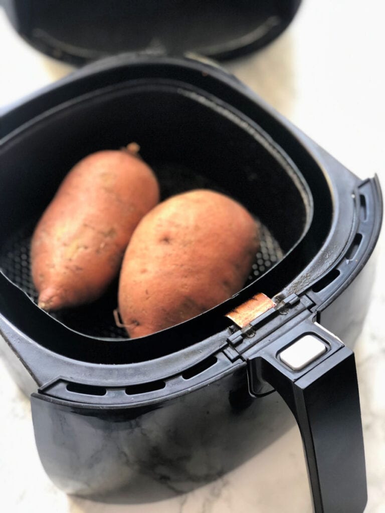 Two sweet potatoes in an air fryer 
