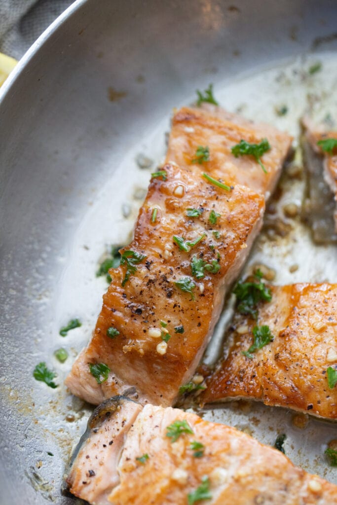 Crispy salmon fillets in a stainless steel pan 
