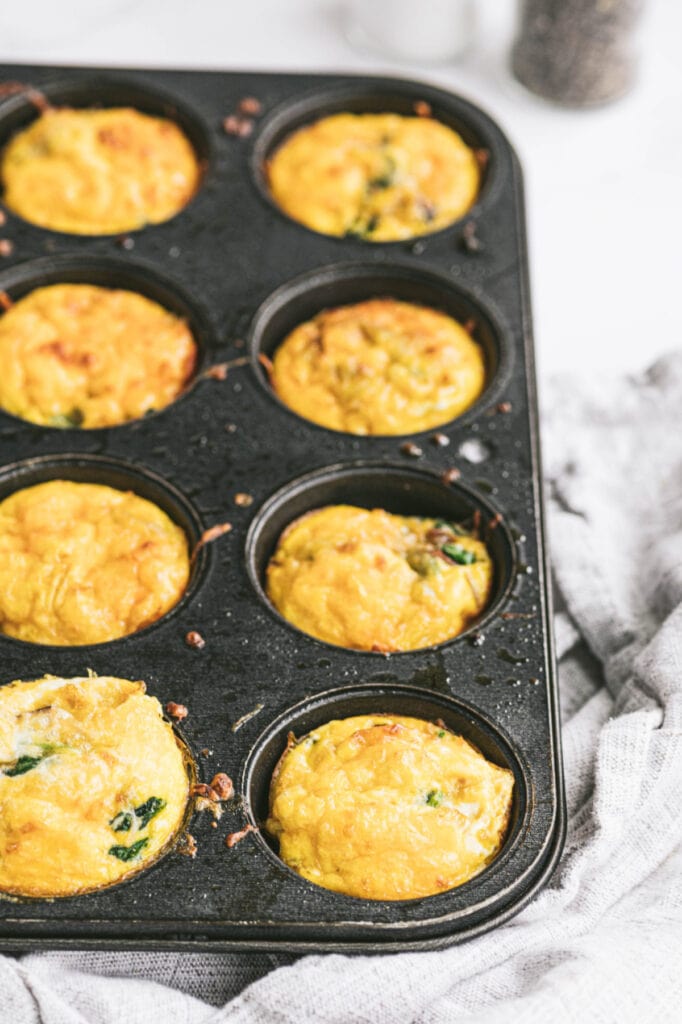 Eight perfectly baked egg bites are in muffin tins. 