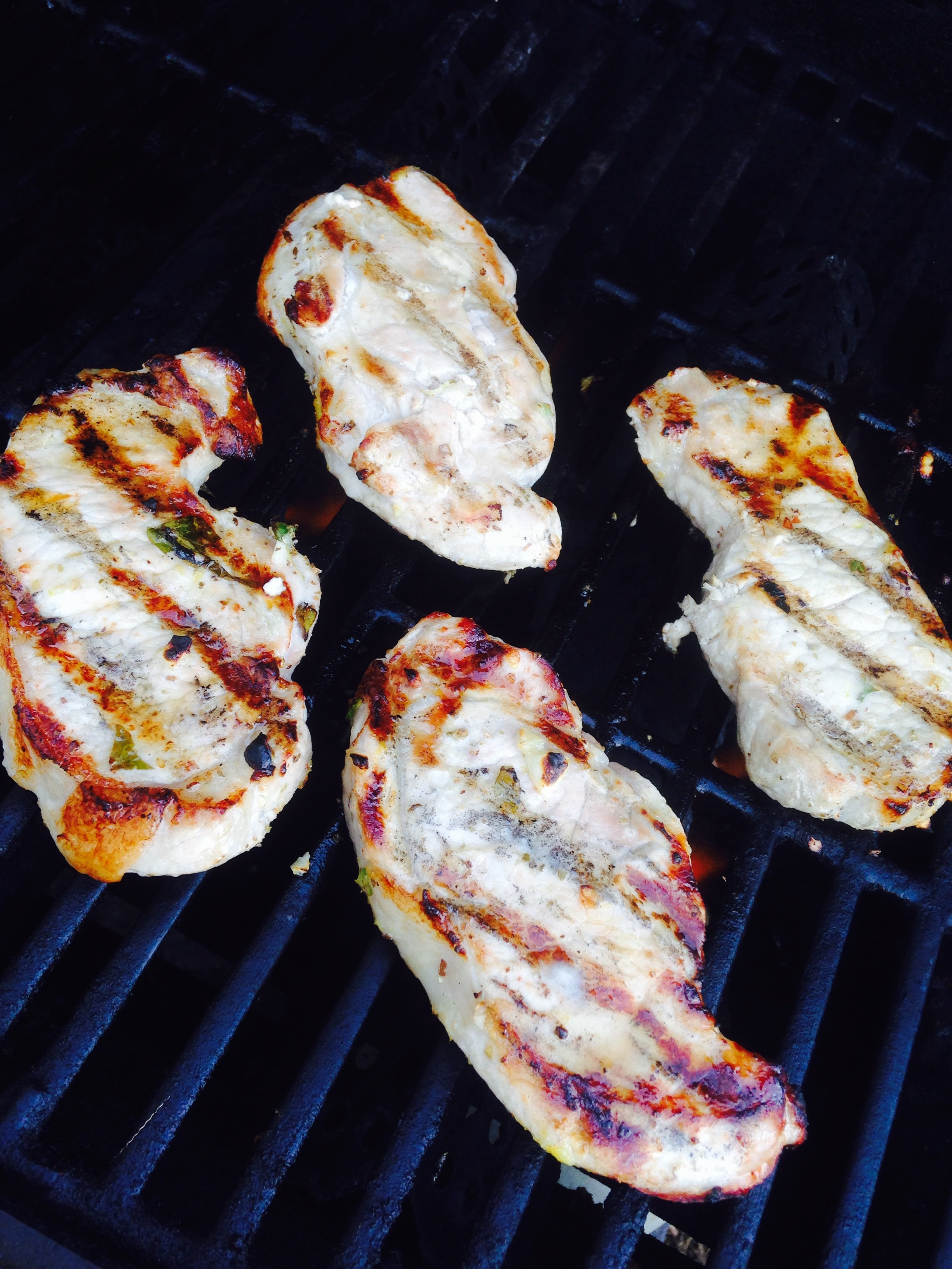 4 porkchops with grill marks lying on the grill