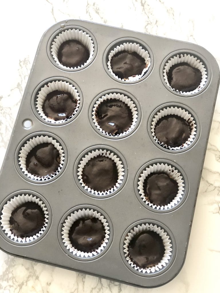 A mini muffin tin filled with healthy homemade peanut butter cups 