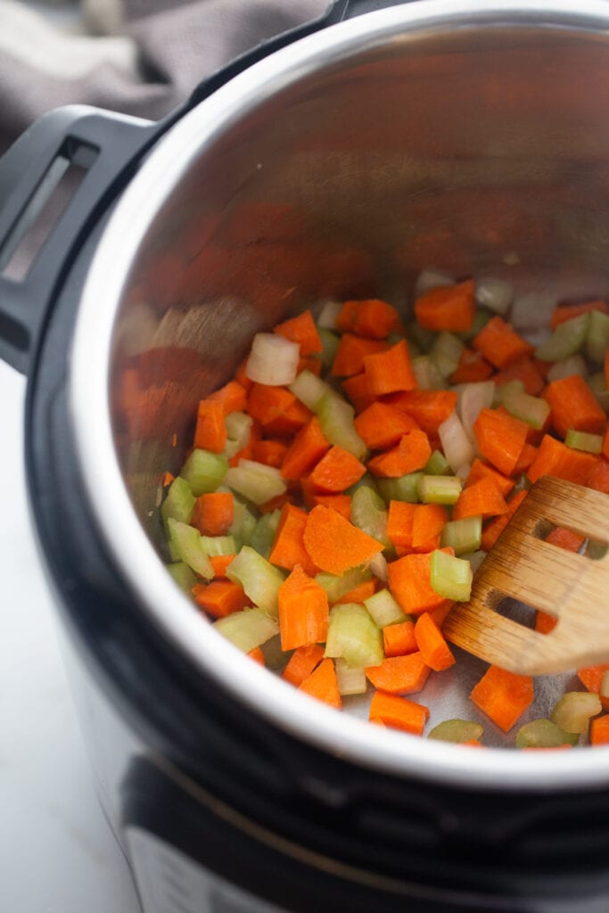 Carrots, onions and celery are sautéed in the Instant Pot.