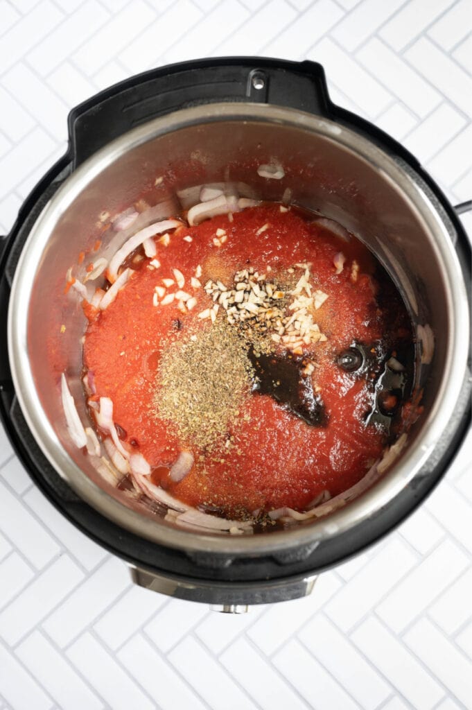 Overhead photo of an Instant Pot full of ingredients ready for balsamic chicken 