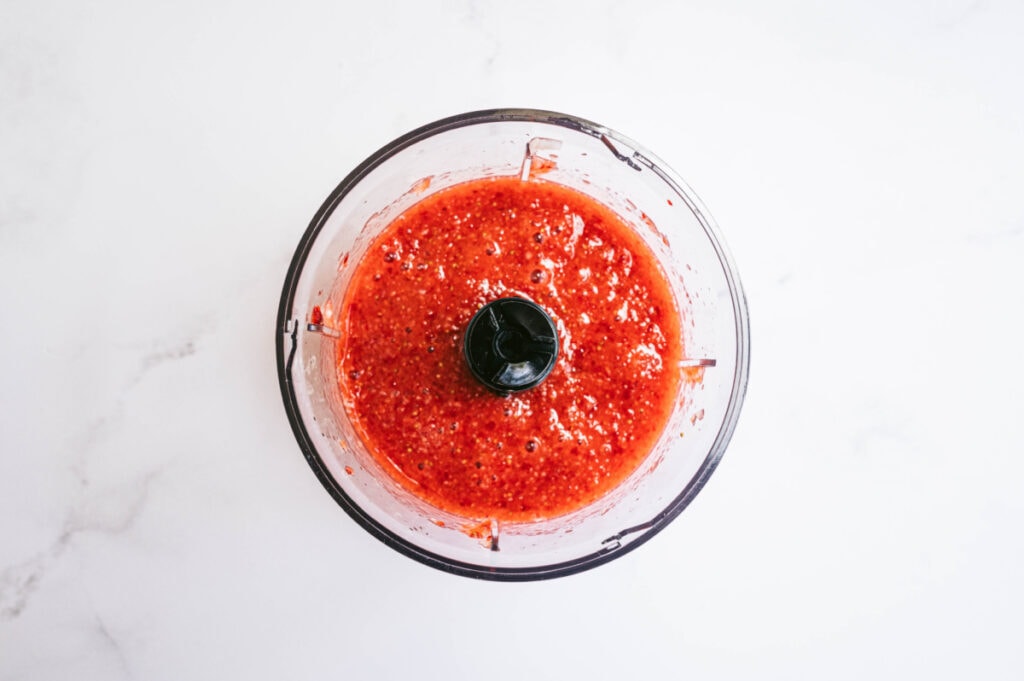 A small food processor with strawberry puree