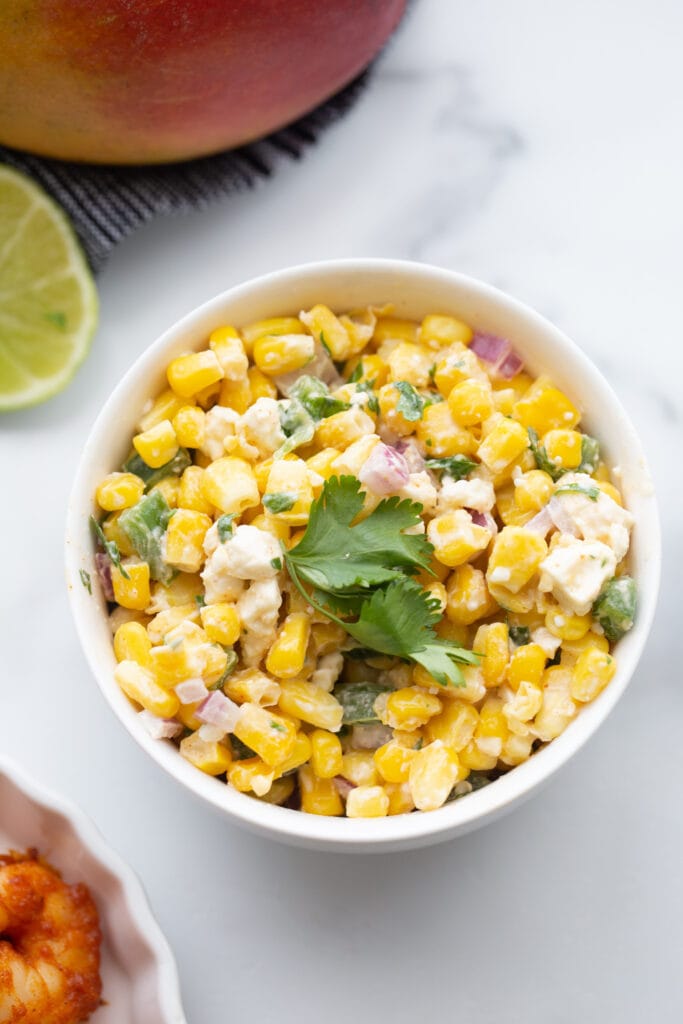 A bowl of Mexican Street corn salad on a white background 